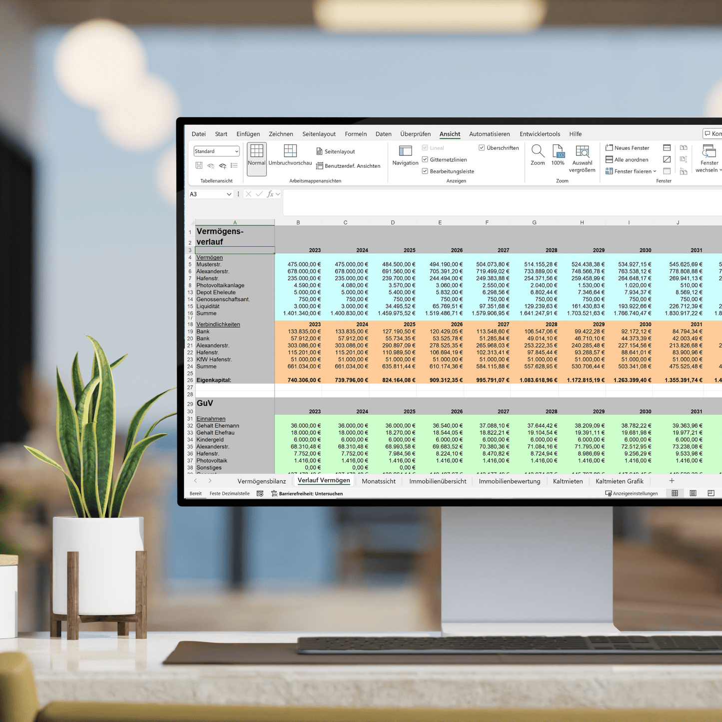 Ein Computerbildschirm zeigt eine detaillierte Excel-Tabelle zur Vermögens- und Gewinn- und Verlustrechnung (GuV) im Zusammenhang mit Immobilieninvestitionen. Die Tabelle enthält farblich kodierte Zahlen für verschiedene Jahre, um den Vermögensverlauf und finanzielle Erträge darzustellen. Im Vordergrund steht eine Zimmerpflanze, während der Hintergrund eines modernen Büros leicht unscharf ist.